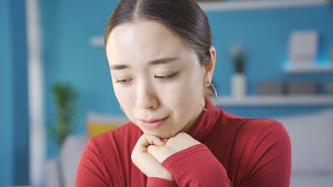Asian-woman-sitting-at-home-unhappy-and-depressed.-(CLOSE-UP)